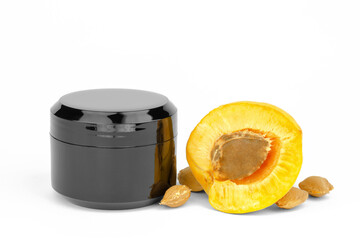 Black jar of moisturizer mockup and fresh apricots. Skin care concept. Apricot Moisturizer