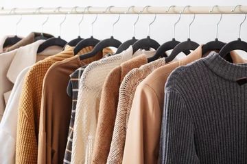 female autumn clothes on hangers  in  white room © Maya Kruchancova