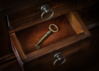 Antique key in a cabinet drawer. Find the right key for the lock. Concept and idea on the theme of security, history, protection, protection, mystery, conservation, etc. Retro style.