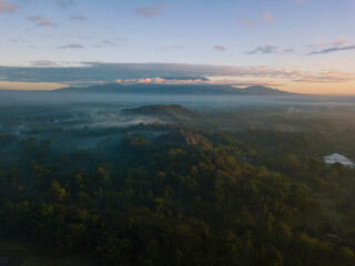 Magnificent Borobudur temple aerial shot in the sunrise time with mountain on the background. Java, Indonesia