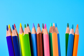 Colorful cryons on the table. Color pencils on blue background.