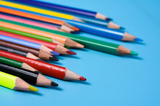Colorful cryons on the table. Color pencils on blue background.