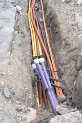 Electric cable underground. Broadband and power Lines in various colors and types of tube. Connection Work on Construction building site.