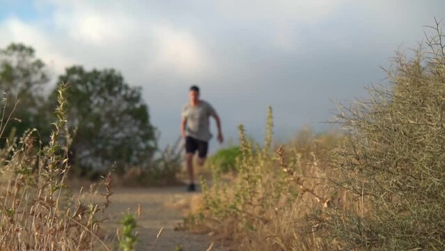 Slow motion young hispanic arab man running in nature
