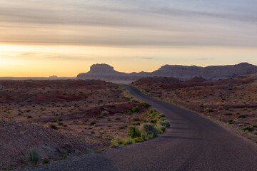 Fototapeta na wymiar Scenic Road surrounded by Red Rock Mountains in the Desert at Sunrise. Spring Season. Goblin Valley State Park. Utah, United States. Nature Background.