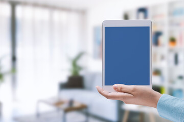 Woman holding a tablet and house interior
