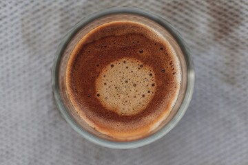 Top view of black coffee with beautiful crema on dirty grey cloth.