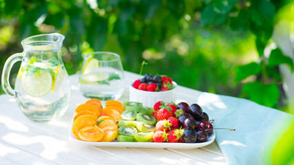 Table in the garden with fruits and lemonade