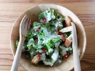 Fresh tomatoes with cucumber, lettuce, red onion and spices in a white bowl. 