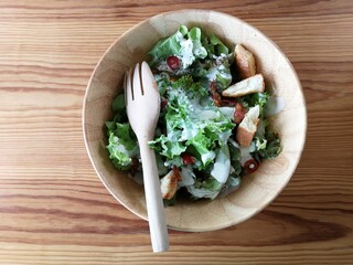 Fresh tomatoes with cucumber, lettuce, red onion and spices in a white bowl. 