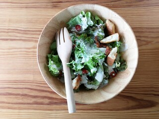 Fresh tomatoes with cucumber, lettuce, red onion and spices in a white bowl. 