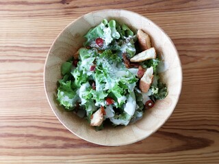 Fresh tomatoes with cucumber, lettuce, red onion and spices in a white bowl. 