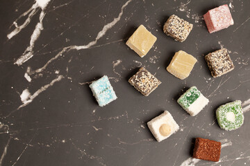 Cubes of traditional oriental sweets on a marble background, top view.