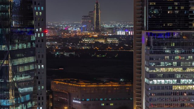 Skyline view of traffic on Al Saada street near financial district night timelapse and Deira creek district with towers on a background in Dubai, UAE. Aerial view between office skyscrapers with