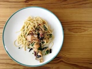 Spaghetti on black plate on wooden background. top view.