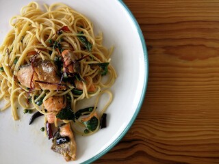 Spaghetti on black plate on wooden background. top view.