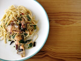 Spaghetti on black plate on wooden background. top view.