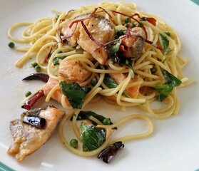 Spaghetti on black plate on wooden background. top view.