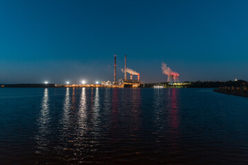 A night view of the lake, in the distance the illuminated chimneys of a coal-fired power plant.