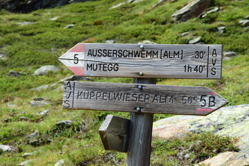 Wooden trail markings in the South Tyrolean mountains, hiking trail with wooden signs