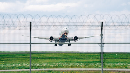 Passenger plane comes in for landing in cloudy weather.