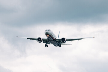 Passenger plane comes in for landing in cloudy weather.