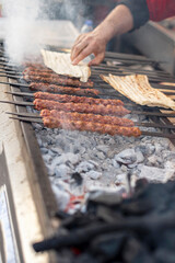 Traditional Adana kebabs are grilling  on a barbecue, close up