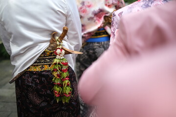 Asian Man wearing traditional Javanese attire with keris. Keris is a traditional Javanese weapon