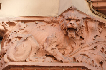Sculpture of a barking cat on the facade of the building.