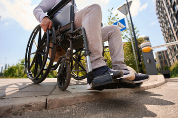 Disabled man going down curb in manual wheelchair