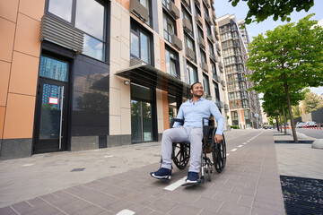 Young wheelchair-bound man looking around business district
