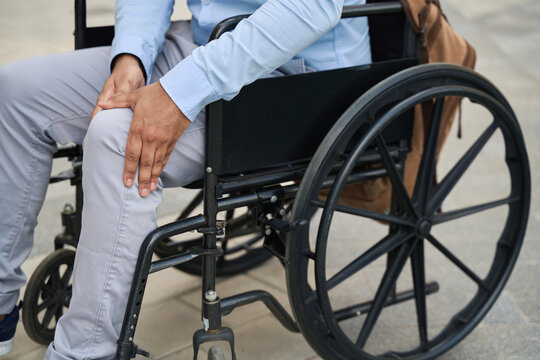 Disabled man experiencing knee joint pain outdoors