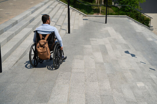 Man with disability descending concrete staircase outdoors