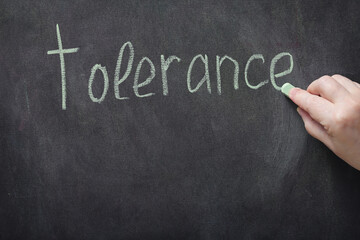 on the black board in white chalk is written the word tolerance