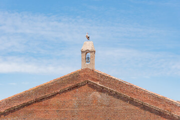 Bell tower of the church of Galisteo with a stork on top, Caceres.