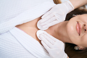 Cleansing the skin of the neck with cotton swabs