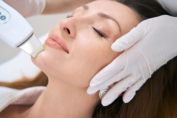 Woman on the procedure of hardware cleaning of the face