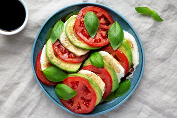 Homemade Organic Avocado Caprese Salad on a Plate, top view. Flat lay, overhead, from above.
