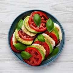 Homemade Organic Avocado Caprese Salad on a Plate, top view. Flat lay, overhead, from above.