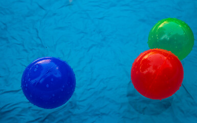 Colorful plastic balls in a blue children's pool, detail