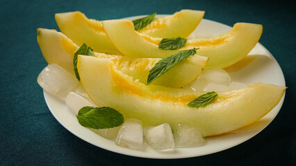 ripe melon with crushed ice and mint leaves, cut into pieces and slices