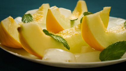 ripe melon with crushed ice and mint leaves, cut into pieces and slices
