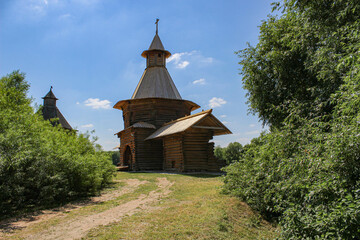 Fototapeta na wymiar An old wooden church standing on a hill among green trees