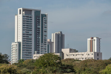 Urban scene shows larger residential and commercial building, residential building and old hotel, parts of the trees, Piracicaba SP Brazil.