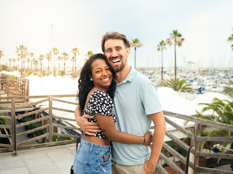 Happy diverse smiling heterosexual young couple looking at camera during vacation. happy couple,honeymoon,vacation