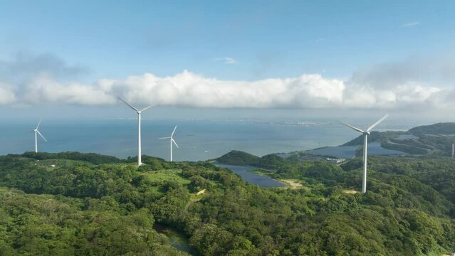 Aerial timelapse: Turbines spin as clouds move over coastal wind farm