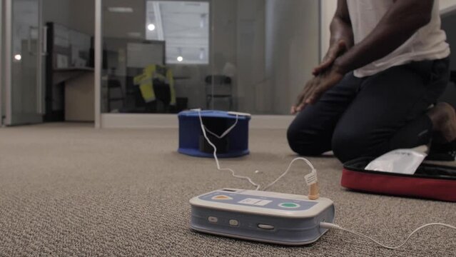 Security guard conducting CPR first aid with the AED.