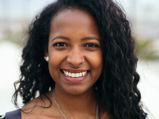 Close up portrait of a young smiling attractive African Latin American woman. Empowered woman, positive emotions