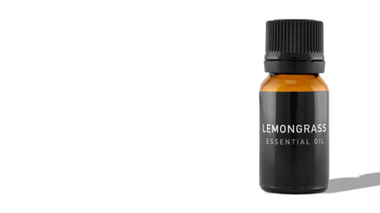 A bottle of lemongrass essential oil with shadow on a white background. The idea of natural cosmetic, natural oils, aromatherapy, emotional wellbeing and skincare. Copy space