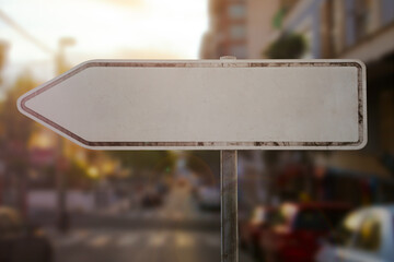 old rusty blank sign board with arrow to left stand in city while sundown is a mock up